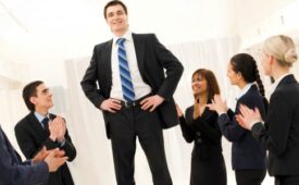 Photo of happy business partners applauding to confident leader surrounded by them