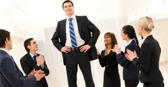 Photo of happy business partners applauding to confident leader surrounded by them