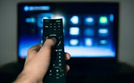 Male hand using Tv remote control