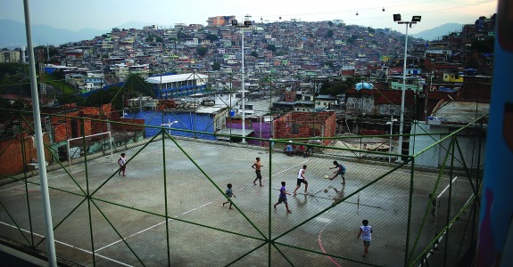 RIO DE JANEIRO, BRAZIL - MAY 18: Kids play soccer in the Complexo do Alemao pacified community, or 'favela' on May 18, 2014 in Rio de Janeiro, Brazil. Ahead of the 2014 FIFA World Cup, Rio has seen an uptick in violence in its pacified slums, including Complexo do Alemao. A total of around 1.6 million Rio residents live in shantytowns, many of which are controlled by drug traffickers. (Photo by Mario Tama/Getty Images)