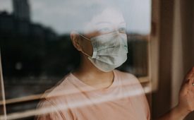 an asian chinese female looking out from her balcony window with her face mask during the restricted movement order in malaysia