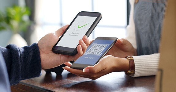 Customer using phone for payment at cafe restaurant, cashless QR code technology and money transfer concept