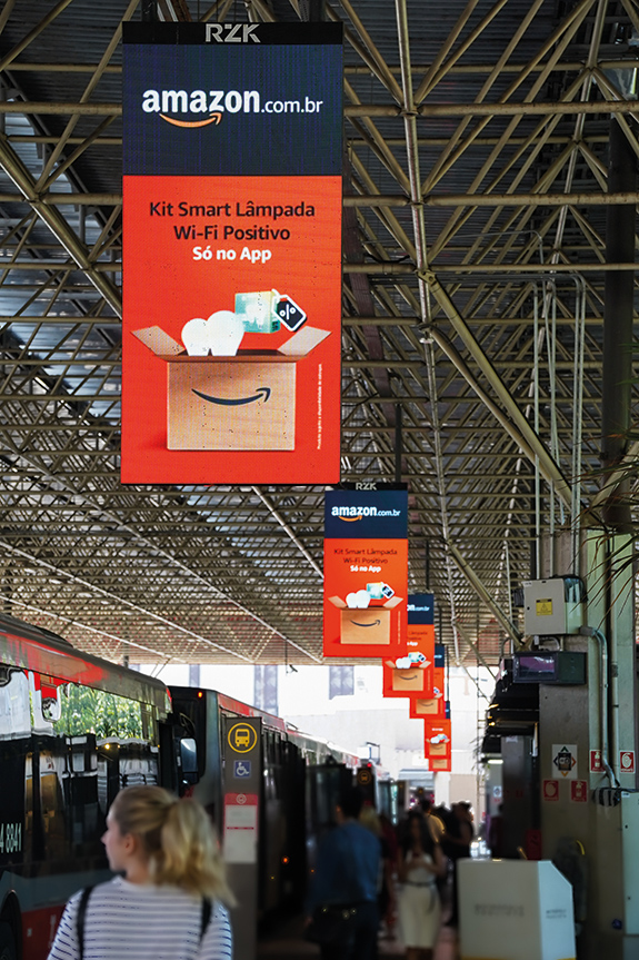 Sequência visual de campanha da Amazon em terminal rodoviário ressalta impacto, alcance e engajamento da RZK Digital em São Paulo
