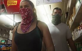Duas pessoas com rostos cobertos em um corredor de supermercado.