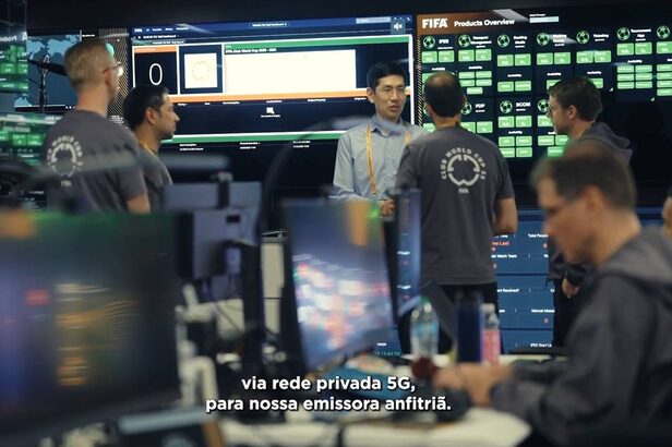 Homens em sala de controle com telas grandes, monitorando transmissão via rede 5G privada.