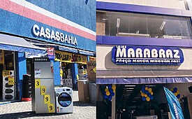 Fachada de loja Casas Bahia com geladeira e máquina de lavar expostas e loja Marabraz com balões.